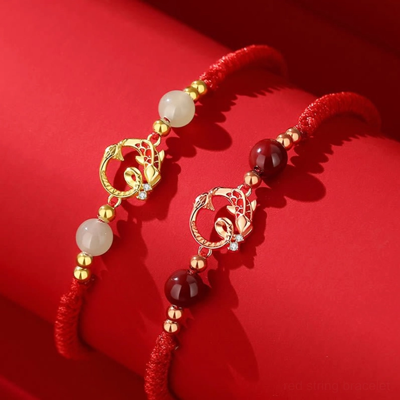 Red string zodiac bracelet with snake koi charm and adjustable sizing flat lay