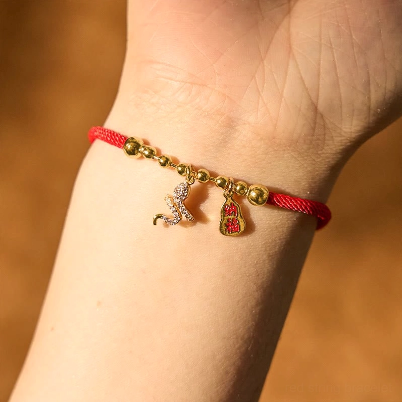 Wearable snake red string bracelet worn on human wrist close-up view