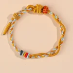 Year of the Snake luck bracelet with colorful twisted braided cord and Chinese decorative knot – flat lay view
