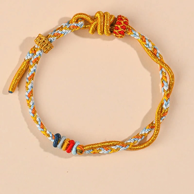 Year of the Snake luck bracelet with colorful twisted braided cord and Chinese decorative knot – flat lay view