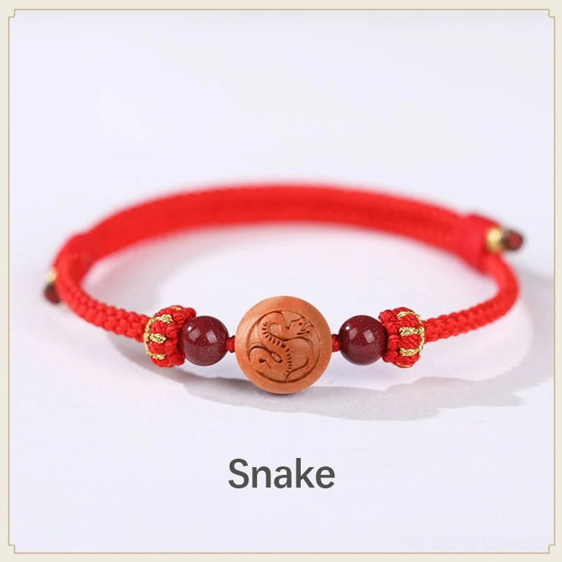 Snake zodiac peach wood charm bracelet with red rope and carved snake detail - wisdom bracelet
