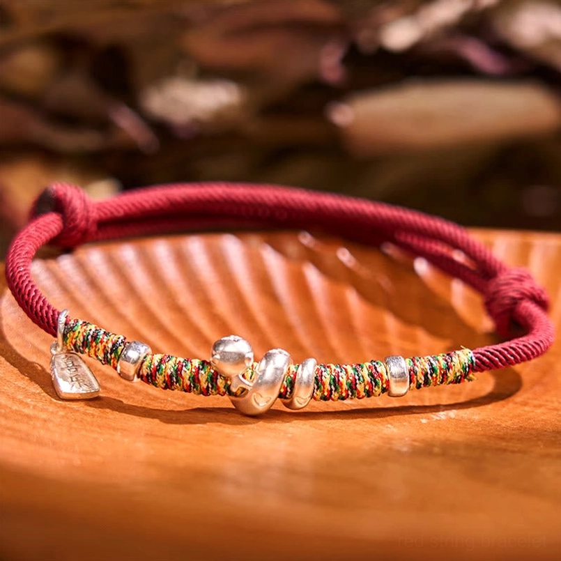 999 Sterling Silver Year of Snake Red String Bracelet top view on wooden table