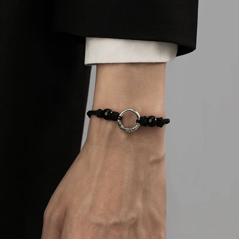 Close up of worn peace buckle protection bracelet under business formal attire