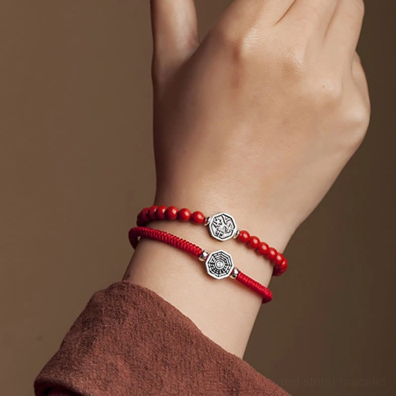 Two yin yang bagua red string bracelets stacked on wrist styling