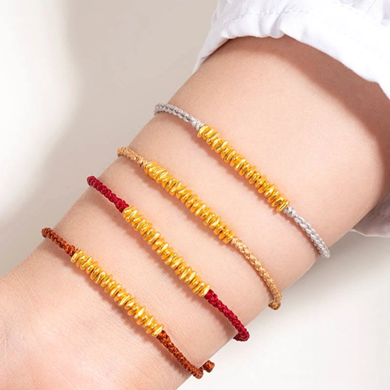 mixed color 999 gold red string bracelets stack on model wrist close up view