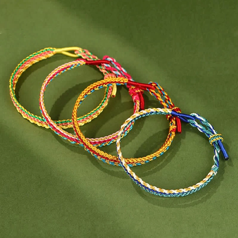 Stack of handmade braided cord bracelets with different color variations showing slip knot design