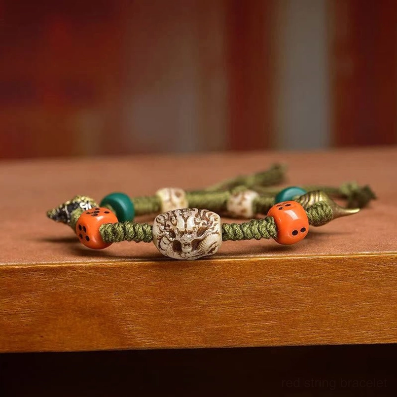 Stacked Tibetan dragon dice rope bracelets on wooden tabletop