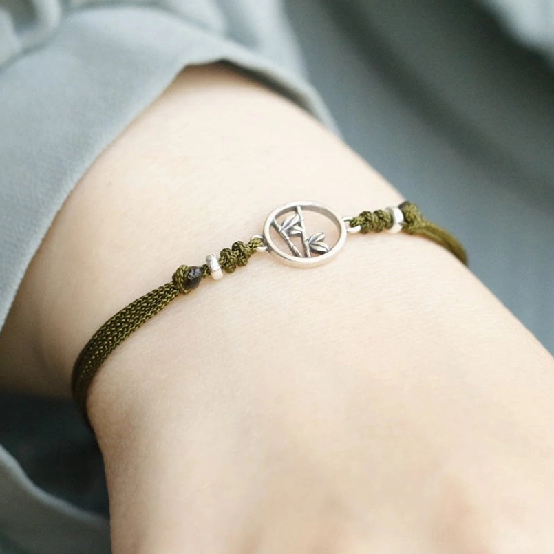 Red string bamboo bracelet worn on wrist showing adjustable sliding knot and daily wear style