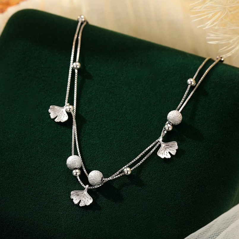 Silver double layer ginkgo leaf ankle bracelet on velvet fabric studio display