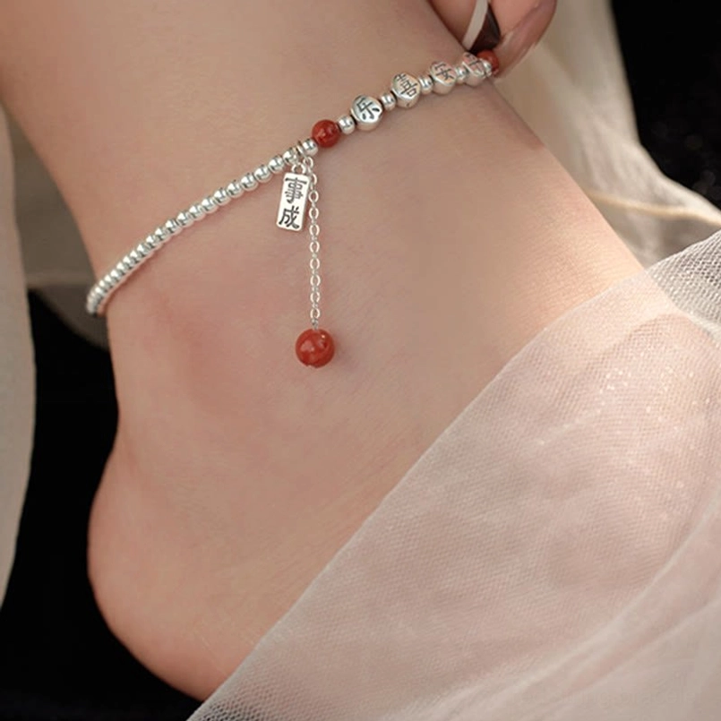 Sterling silver blessing anklet with red agate and engraved character beads on wrist