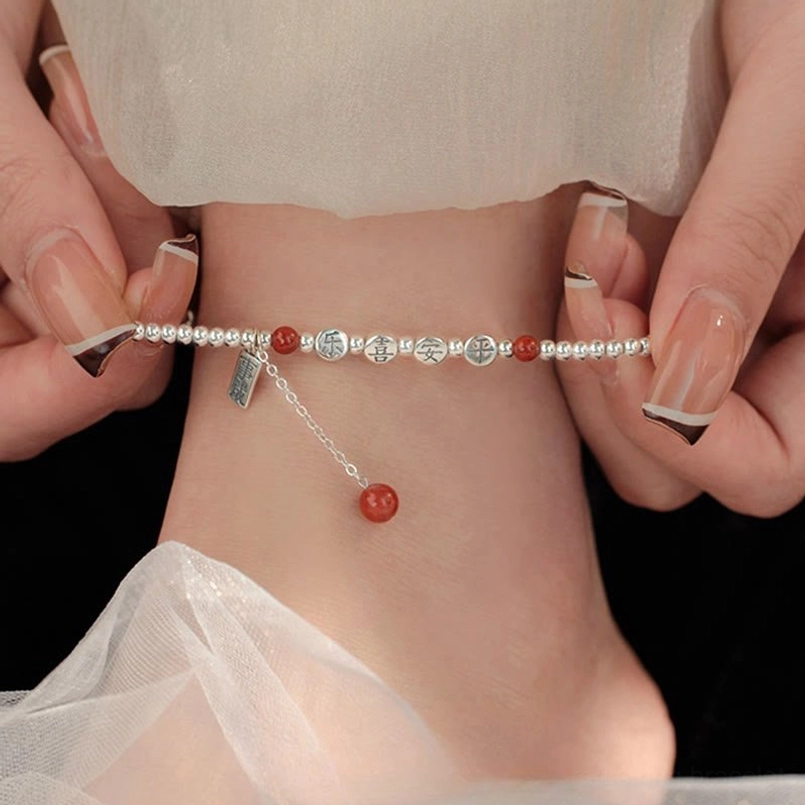 925 sterling silver red agate peace and joy blessing anklet worn on ankle with sheer fabric backdrop