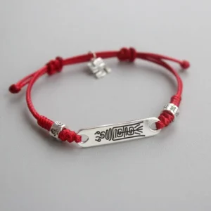 925 sterling silver red string bracelet with braided cord and engraved silver plate, flat lay view