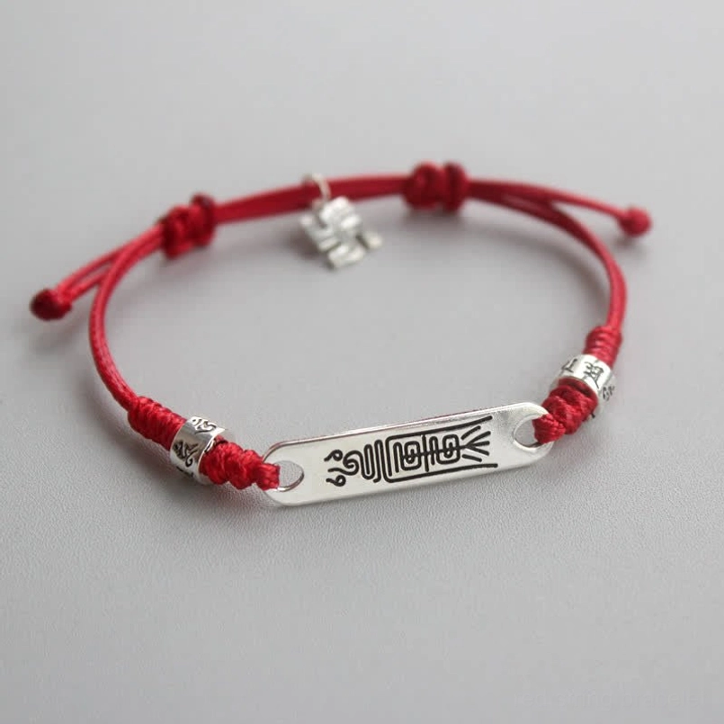925 sterling silver red string bracelet with braided cord and engraved silver plate, flat lay view