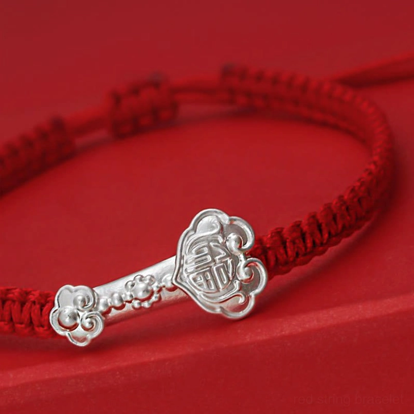 Close-Up Detail of Engraved 999 Sterling Silver Ruyi Fu Charm on Braided Red String Bracelet