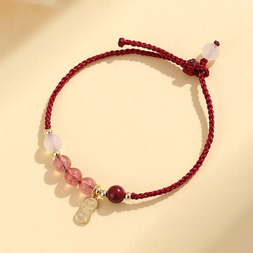 Close up detail of natural strawberry quartz bead on red string bracelet