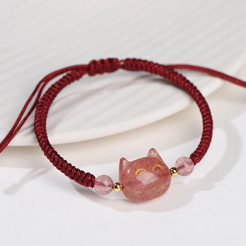 Strawberry Quartz cat charm bracelet close-up, showing pink quartz bead and gold spacer details on light background