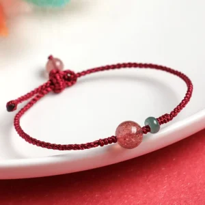 Strawberry Quartz Red String Bracelet with Natural Jade flat lay on white plate
