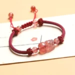 Strawberry Quartz Pixiu Red String Bracelet side view showing woven cord and carved focal bead