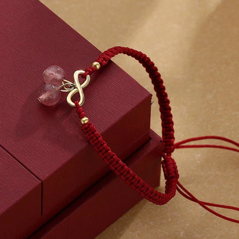 Red string bracelet showing adjustable tail cords and frosted strawberry quartz pendants
