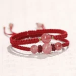 Double-layer red string strawberry quartz bracelet with pink crystal beads on calligraphy background
