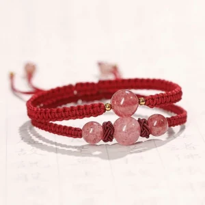 Double-layer red string strawberry quartz bracelet with pink crystal beads on calligraphy background