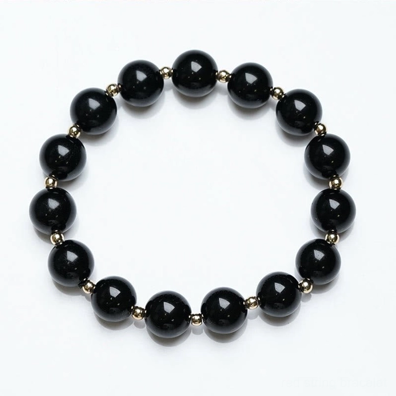 single stretch black onyx beaded bracelet with gold spacers flat lay