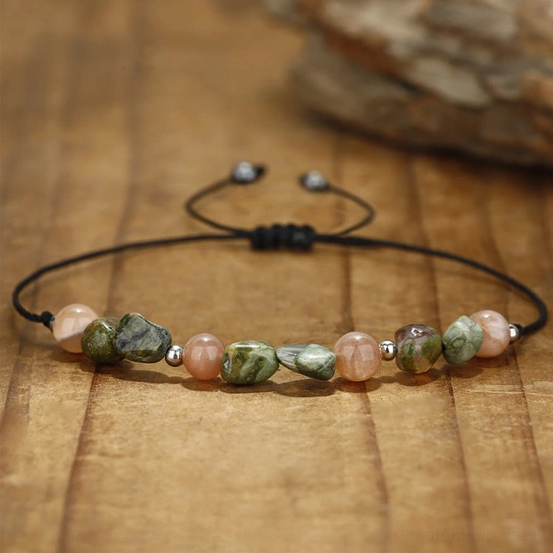 Minimalist natural stone bracelet with thin black waxed cord on rustic wood