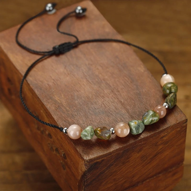 Three-quarter view of adjustable stone bracelet with pull-tie black cord closure