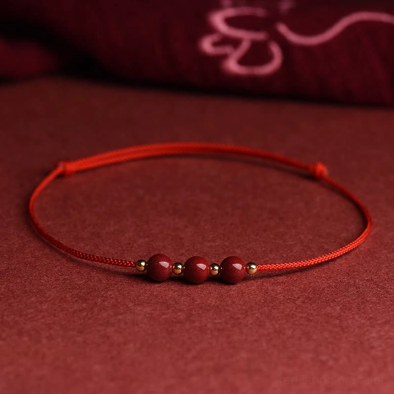 Three cinnabar bead red string bracelet full display on solid background