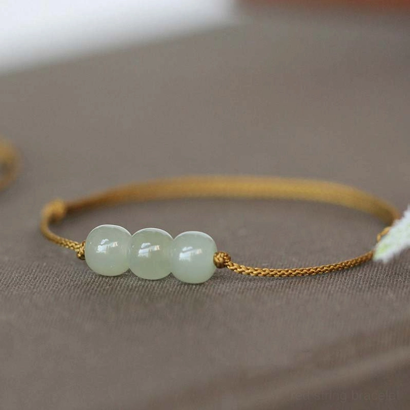 Brown string jade bracelet three beads flat lay on gray fabric - alternative color option