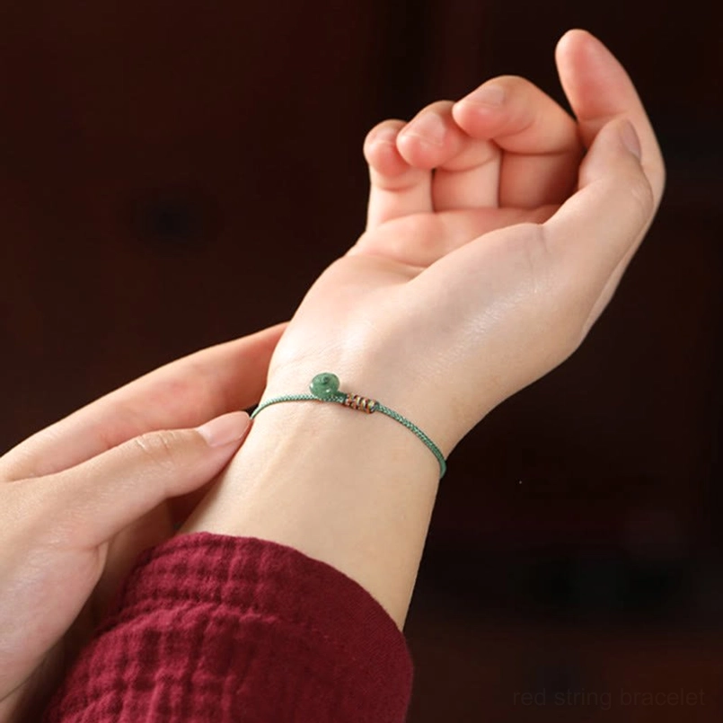 Lifestyle close-up of green aventurine braided bracelet worn on wrist with hands adjusting the jewelry