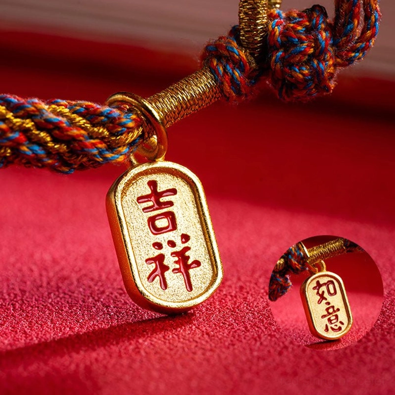 Tibetan auspicious bracelet charms featuring engraved Ruyi gold tag and Ji Xiang charm on red velvet