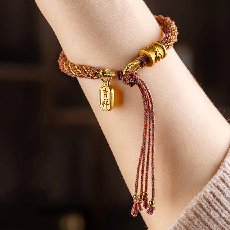 Tibetan braided fortune bracelet with Ruyi gold pendant and colorful tassel detail on wrist