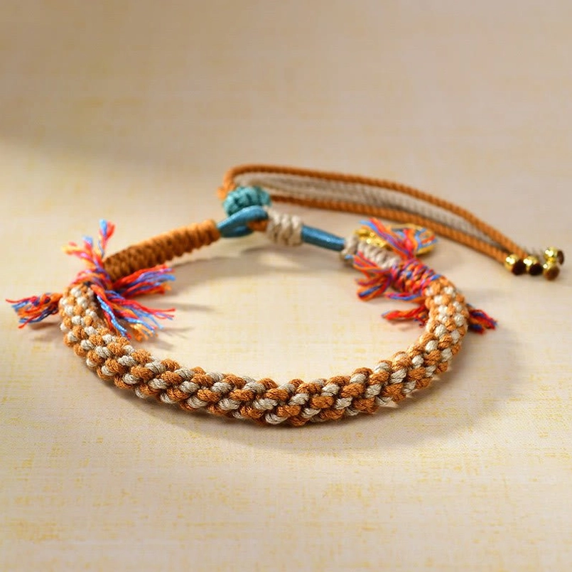 Tibetan multi color braided protection string bracelet flat lay view