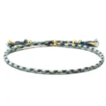 Handmade Tibetan braided rope tassel bracelet in blue-green tones with gold copper spacer beads - flat lay view