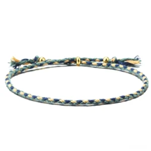 Handmade Tibetan braided rope tassel bracelet in blue-green tones with gold copper spacer beads - flat lay view
