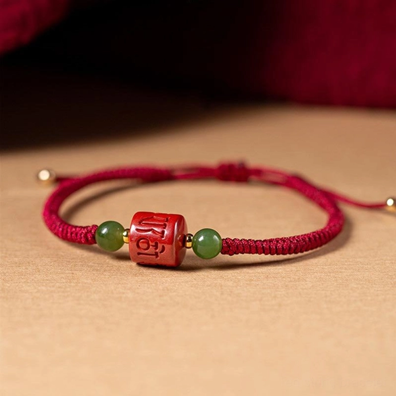 Side profile of Tibetan cinnabar red string bracelet with gold metal spacers and jade beads