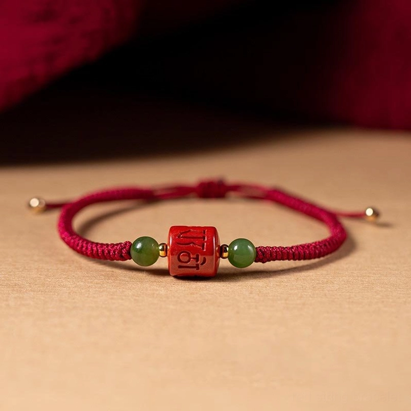 Tibetan cinnabar om mani padme hum red string bracelet with jade beads, top-down flat lay view