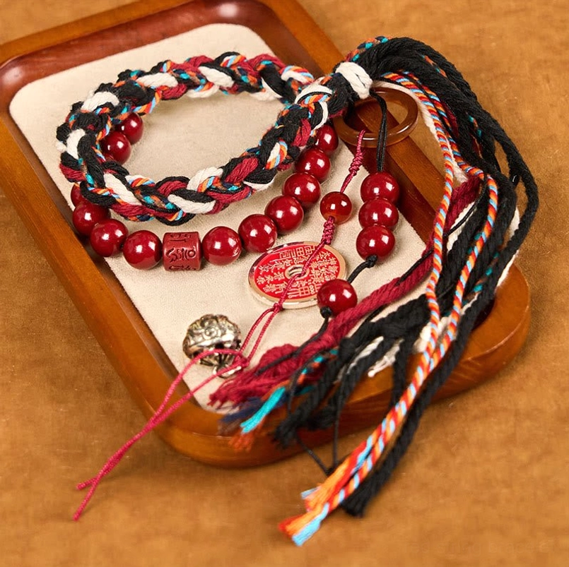 Tibetan cinnabar mountain ghost red string protection bracelet flat lay on wooden tray