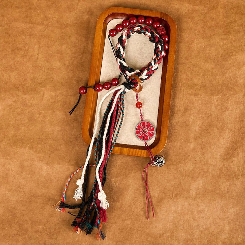 Tibetan cinnabar prayer tassel red string bracelet oblique top view