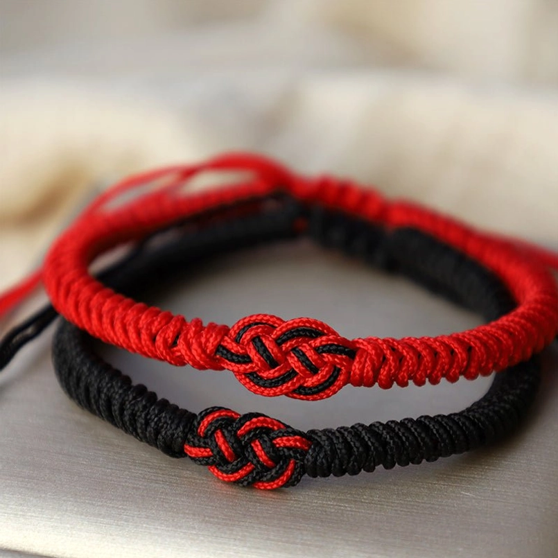 Overhead view of Tibetan red string couple bracelets showing double knot design and braided rope texture