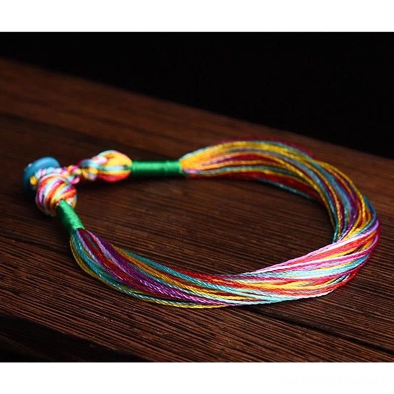 Tibetan five color woven festival bracelet flat lay on wooden table
