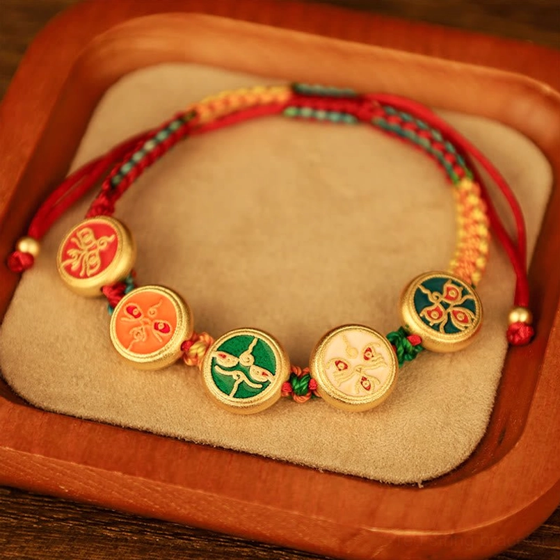 Adjustable braided rope Tibetan Five Gods wealth bracelet side angle view with decorative gold-toned pendants