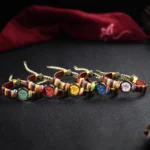 Tibetan five wealth gods Buddha eye blessing bracelets collection set in multiple colors on red fabric backdrop