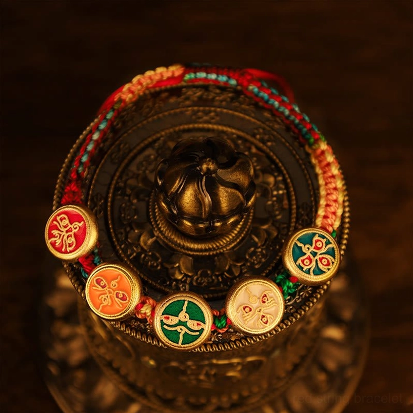 Tibetan Five Fortune Gods braided bracelet wrapped around metal vessel showing complete charm set design