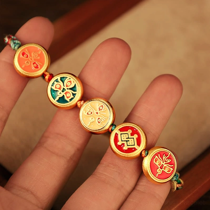 Close-up detail of five unique enamel pendants on Tibetan wealth bracelet displaying lucky Tibetan motifs