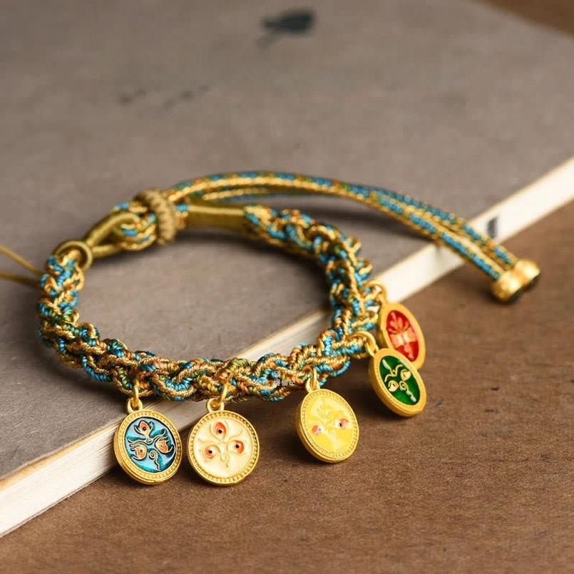 Tibetan five gods of wealth braided bracelet with enamel pendants on wooden surface