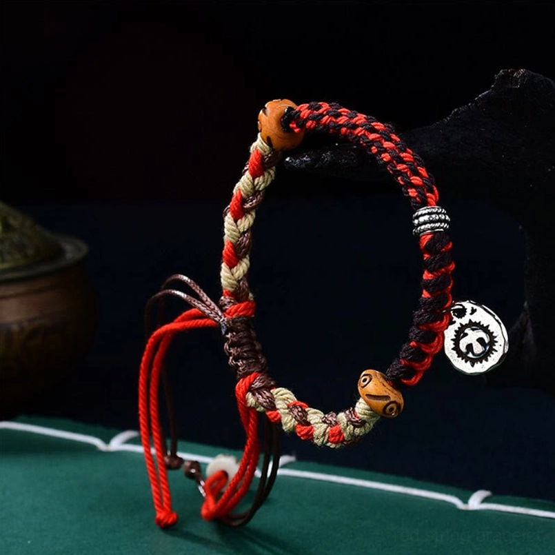 Tibetan hand-woven Garuda luck bracelet front view showing braided cord design and metal charm