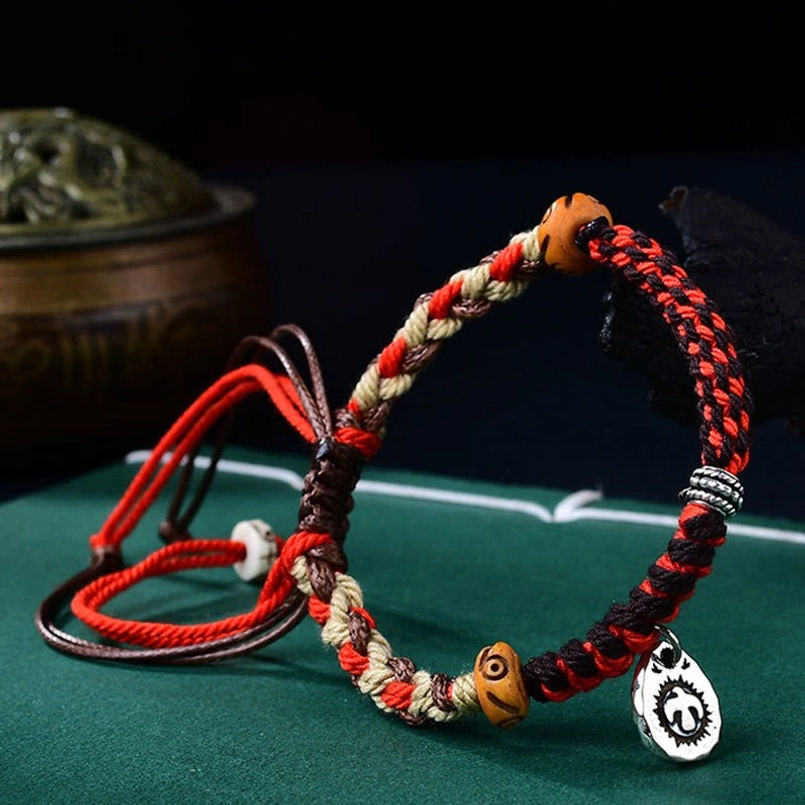 Side view of Tibetan Garuda protection bracelet showing braided rope and extension cords