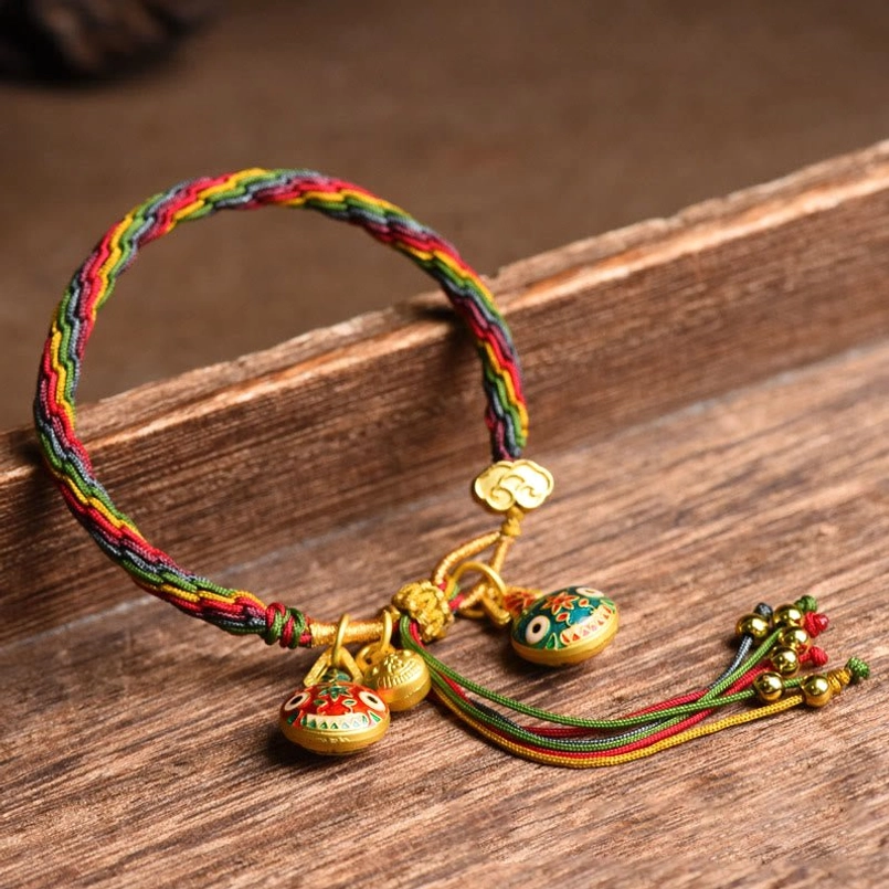 Tibetan Gold Swallowing Beast colorful braided string bracelet on wooden table